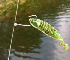 a green insect hanging from a fishing line