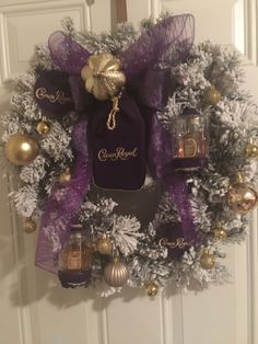 a wreath with purple and gold decorations on the front door is adorned with an ornament