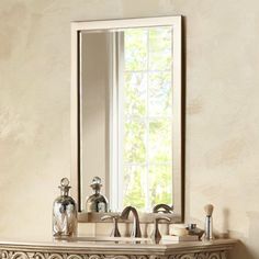 a bathroom sink sitting under a large mirror next to a wall mounted faucet