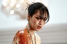 a close up of a woman with freckles on her face and body covered in mud