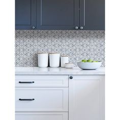 a kitchen with blue and white wallpaper, cabinets and bowls on the countertop