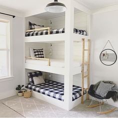 a white bunk bed with black and white checkered bedspread in a bedroom