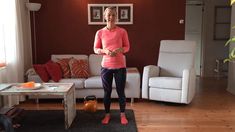 a woman standing in front of a living room with a white couch and coffee table