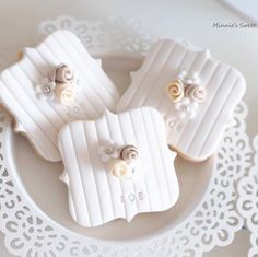 some cookies that are sitting on a white lace doily with gold buttons and bows