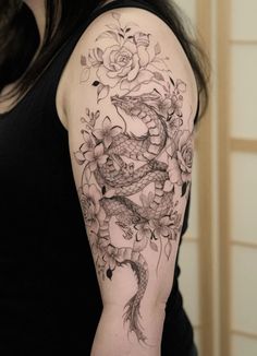 a woman with a dragon and roses tattoo on her arm