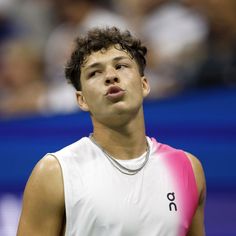 a young man holding a tennis racquet on top of a tennis court