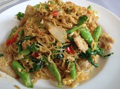 a white plate topped with noodles and vegetables