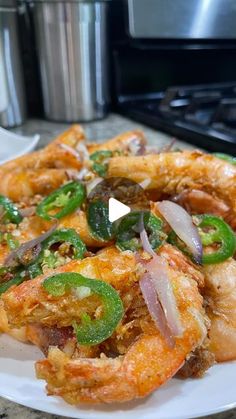 a white plate topped with shrimp and green peppers