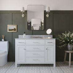 a bathroom with green walls and white fixtures, including a sink, mirror, toilet and bathtub