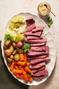 a white plate topped with meat, potatoes and carrots