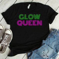 "Glow Queen Party shirt | Glowing 80's Effect Retro Tee | Party Celebration Unisex Shirt | Short-Sleeve Queen Of The Party Funny T-Shirt We print on everything! In our shop you will find our designs mostly on short sleeve shirts, but since we use Printful's printing services we can print any design on any type of shirt or item you can see here: https://www.printful.com/custom-products You are welcome to send us a message if you want a design printed on any of the items on the Printful website. G Cheap Party T-shirt With Text Print, Spring Party Tops With Text Print, Trendy Screen Print T-shirt For Party, Multicolor Letter Print Tops For Party, Trendy Neon Crew Neck Top, Black Crew Neck T-shirt For Party Season, Neon Graphic Print Short Sleeve Top, 90s Short Sleeve Party Tops, Neon Short Sleeve Top With Graphic Print