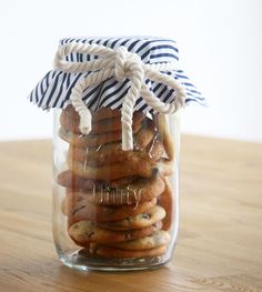 a jar filled with cookies sitting on top of a wooden table