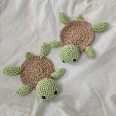 two crocheted sea turtles laying on top of a bed