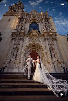 a bride and groom standing on the steps of a church