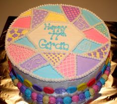 a birthday cake decorated with colorful icing and candies on a foil sheeted surface