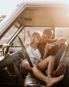 a man and woman sitting in the back seat of a truck kissing on their foreheads