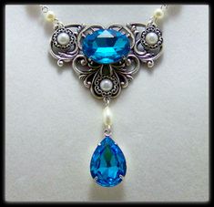 Medieval Necklace - Victorian Jewelry - Renaissance Jewelry, Tudor Necklace, Victorian Necklace, Medieval Jewelry, Victorian Wedding: This necklace is made to order and will take 1 to 2 weeks to ship. Made with my 2 favorite eras in mind this necklace would be the perfect accessory for a Lady of the royal court or a Lady of Victorian elegance. The center piece of the necklace is made with a sturdy silver plated brass filigree on which is afixed an 18x13mm facated glass stone in a vibrant blue hu Medieval Handmade Wedding Jewelry, Handmade Medieval Necklaces For Larp, Medieval Silver Wedding Jewelry, Medieval Style Silver Wedding Jewelry, Historical Wedding Pendant Jewelry, Gothic Wedding Necklaces With Jewels, Handmade Fantasy Style Necklace For Wedding, Medieval Jewelry With Historical Design As Gift, Medieval Jewelry With Historical Design For Gift