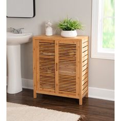 a wooden cabinet next to a sink in a bathroom