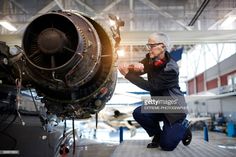 a man working on an airplane in a hanger with the engine still attached to it