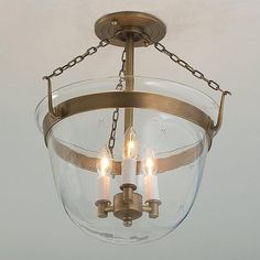 a light fixture with three candles hanging from it's center and two lights on each side