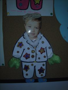 a photo of a young boy wearing a white jacket and green pants with stars on it