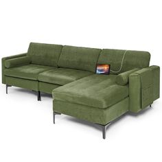 a green sectional sofa with an ottoman on it's side and a small table next to it