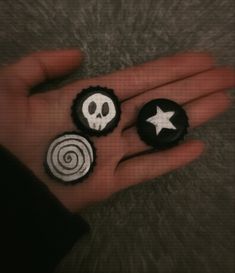 two black and white buttons in the palm of someone's hand with a star on it