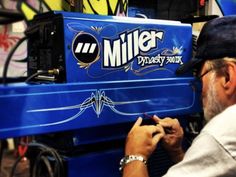 a man is working on a machine in a shop that sells miller's products