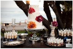 a table topped with a white cake and lots of cupcakes on top of it