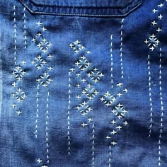 an embroidered blue jean jacket with white stars on the front and back side, showing stitching