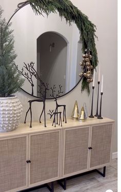 a mirror sitting on top of a dresser next to a christmas tree and other decorations