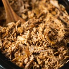 the food is being cooked in the slow cooker with wooden spoons on it