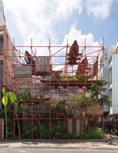 scaffolding on the side of a building that has plants growing out of it