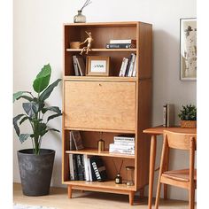 a wooden book shelf with books on it next to a chair and potted plant