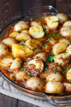 a casserole dish filled with potatoes and sauce