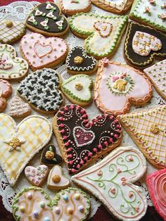 many different decorated cookies on a doily