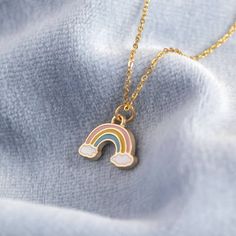 "A lovely gold plated pastel rainbow necklace. This gorgeous dainty little rainbow necklace will brighten up your day and it serves as a powerful reminder of hope and positivity. The rainbow and clouds charm is suspended from a delicate gold plated trace chain. The necklace is presented with the sentiment card of your choice in a lovely organza gift bag. If you would like to upgrade your purchase to include a gift box please order here: https://www.etsy.com/uk/listing/546539022/gift-box-order-up Rainbow Necklace Jewelry, Iris Cabin, Emoji Jewelry, Rainbow And Clouds, Kid Pendant, Rainbow Accessories, Pastel Jewelry, Rainbow Pendant, Jewelry Kids