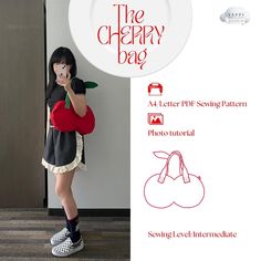 a girl is holding a heart shaped object in front of her face while standing next to a sign that says the cherry bag