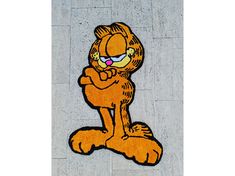 the garfield cat rug is on the ground next to a sidewalk with it's eyes closed