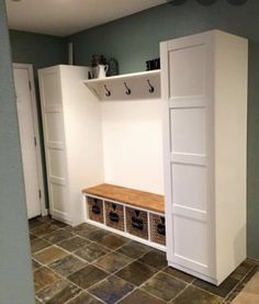 a room that has some white cabinets and drawers in it with hooks on the wall