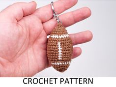 a crochet football keychain is shown in the palm of someone's hand