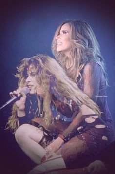 two women on stage with one holding a microphone