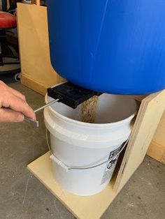 a person is using a tool to fix a bucket