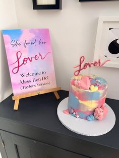 a birthday cake sitting on top of a table next to a sign that says love