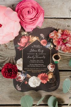 the wedding stationery is surrounded by flowers and greenery, such as peonies