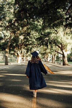 a woman in graduation gown walking down the street