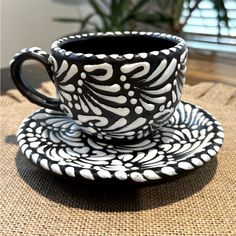 a black and white coffee cup sitting on top of a saucer