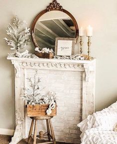 a white fireplace with a mirror above it and flowers in a basket next to it