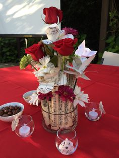 a vase filled with flowers sitting on top of a red table cloth covered tablecloth