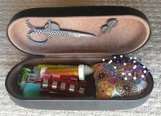 an open case filled with lots of crafting items on top of a wooden table